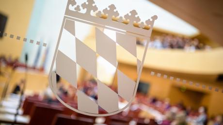 Ein Wappen mit der Bayernraute ist während einer Landtagssitzung im Plenarsaal vom Maximilianeum auf einer Glasscheibe zu sehen.  
