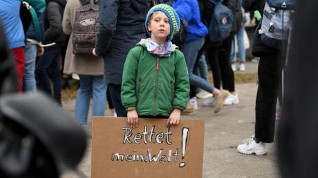 Ein sechsjähriger Teilnehmer einer Schülerdemo in Berlin hält ein Schild mit der Aufschrift "Rettet meine Welt!" Von der Kanzlerin bekamen die Demonstranten nun Unterstützung.
