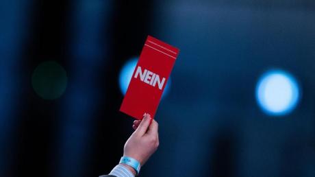 Einige Delegierte heben ihren Stimmzettel mit der Aufschrift "Nein" nach der Rede von Jörg Meuthen beim Bundesparteitag der AfD.
