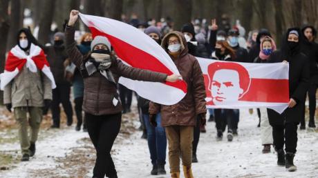 Demonstranten tragen bei einer Kundgebung in Minsk, auf der sie den Rücktritt von Machthaber Lukaschenko fordern, Fahnen in den Farben der früheren belarussischen Nationalflagge.
