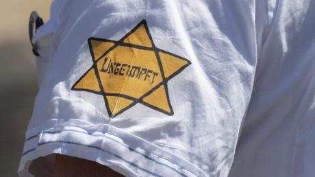 "Ungeimpft" steht auf einem nachgebildeten Judenstern am Arm eines Mannes, der versucht hatte, sich unter die Teilnehmer einer Demonstration in Frankfurt im Mai vergangenen Jahres zu mischen, die sich auch gegen Verschwörungstheorien zum Corona-Virus wendet.