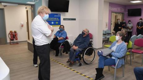 Der britische Premier Boris Johnson (l) bei einem Besuch eines Corona-Impfzentrums in London.