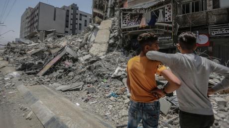 Waffenruhe in Gaza. Zwei junge Palästinenser blicken auf einen zerstörten Wohnblock. Die israelischen Vergeltungsangriffe gegen die Raketen-Angriffe der Hamas aus Israel haben tiefe Spuren hinterlassen.  	 	