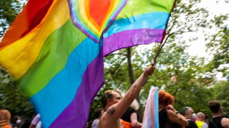 Ein Teilnehmer der «CSD Berlin Pride» trägt eine Regenbogenfarbene Flagge mit einem Herz. (Symbolbild).