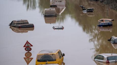 Autos stehen auf der überfluteten Bundesstraße 265 in Erftstadt im Wasser.