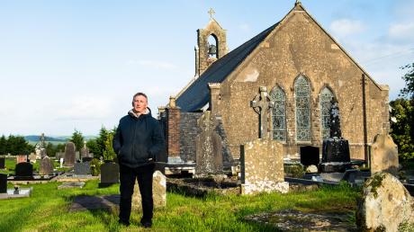 Gerry Quinn auf dem Friedhof seiner Heimatgemeinde Boho. Obwohl er hier aufwuchs, kannte er die Legende von Pfarrer James McGirr nicht. 	
