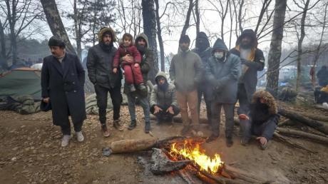 Migranten versammeln sich an der belarussisch-polnischen Grenze an einem Feuer, um sich zu wärmen. 