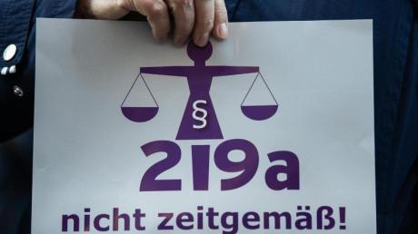 Eine Frau hält bei einer Kundgebung einen Zettel mit der Aufschrift "219a nicht zeitgemäß!". Das Werbeverbot für Abtreibungen könnte bald Vergangenheit sein.