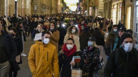 Menschen gehen durch eine Einkaufsstraße in Rom. In Italien sind die Corona-Zahlen erneut in die Höhe geschossen.