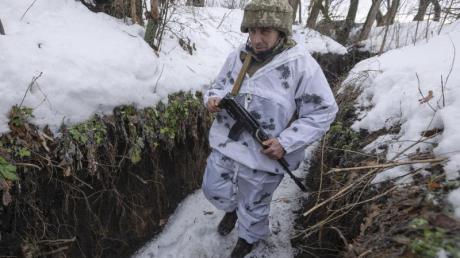 Ein ukrainischer Soldat geht an der Frontlinie zu prorussischen Rebellen in der Region Donezk in einem Schützengraben entlang.