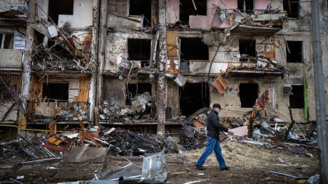 Ein Mann geht an einem Gebäude in der ukrainischen Hauptstadt Kiew vorbei, das nach einem Raketenangriff beschädigt wurde. Auch im Kreis Dillingen machen sich Menschen große Sorgen um die Ukrainer.