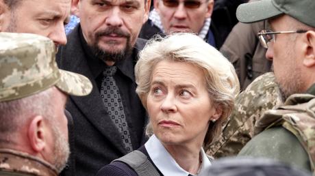 Ursula von der Leyen, Präsidentin der Europäischen Kommission, geht mit schusssicherer Weste zu einem Massengrab in Butscha.