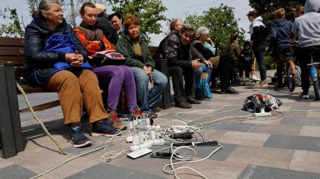 Menschen in Mariupol laden ihre Telefone auf - das Gebiet in der Ostukraine steht unter der Regierung der sogenannten Donezker Volksrepublik.