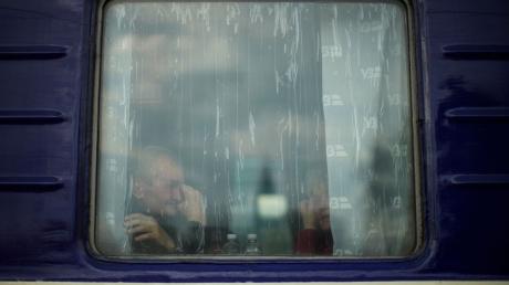 Ein Mann sitzt in einem Evakuierungszug, der den Bahnhof von Pokrowsk in der Ostukraine verlassen soll.