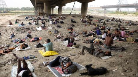 Obdachlose schlafen an einem heißen Tag in Neu-Delhi im Schatten einer Überführung. In der indischen Hauptstadt und den umliegenden Gebieten herrscht eine extreme Hitzewelle.