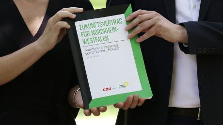 Ministerpräsident Hendrik Wüst (r.) und die Grünen-Vorsitzende Mona Neubaur stellen den Koalitionsvertrag von Schwarz-Grün in NRW vor.