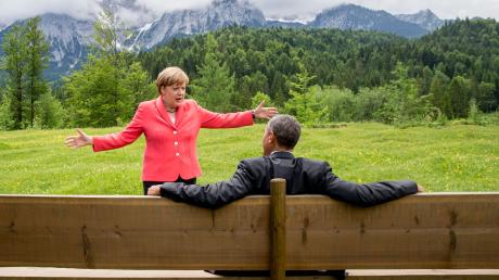Die damalige Bundeskanzlerin Angela Merkel spricht mit dem damaligen US-Präsidenten Barack Obama bei der G7-Konferenz 2015 auf einer Wiese bei Schloss Elmau vor der Wettersteinspitze.