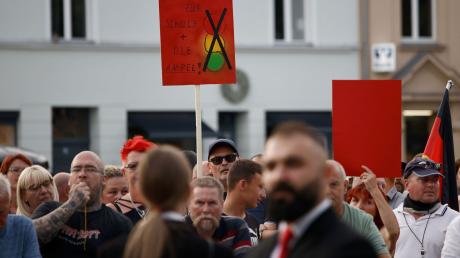 Zuschauer protestieren während der Rede von Bundeskanzler Olaf Scholz bei einer Dialogveranstaltung Bürgern in Neuruppin.