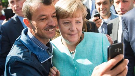 Angela Merkel lässt sich im September 2015 in Berlin für ein Selfie zusammen mit dem Flüchtling Schakir Kedida fotografieren.