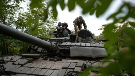 Ukrainische Soldaten auf einem T-80-Panzer bei Bachmut, den sie nach eigenen Angaben von der russischen Armee erbeutet haben.
