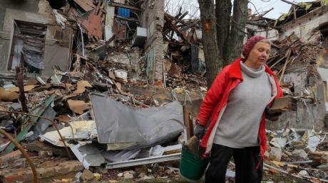 Anwohnerin Nina (72) trägt in Slowjansk hölzerne Trümmer in der Nähe ihres Hauses, das durch Beschuss vor einem Monat zerstört wurde.