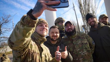 Ukrainische Soldaten machen ein Selfie mit Wolodymyr Selenskyj während seines Besuchs in Cherson.
