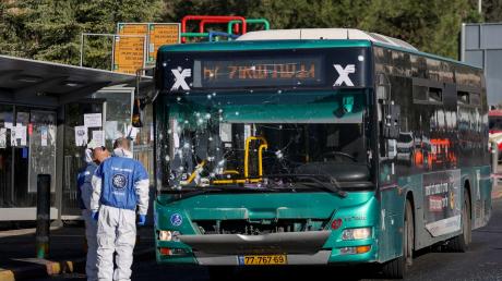 Israelische Polizisten der Spurensicherung ermitteln am Ort einer Explosion an einer Bushaltestelle.