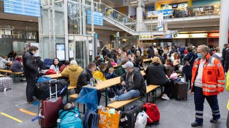 Geflüchtete aus der Ukraine sitzen nach der Ankunft im Flughafen Erfurt-Weimar und werden von Helfern betreut.