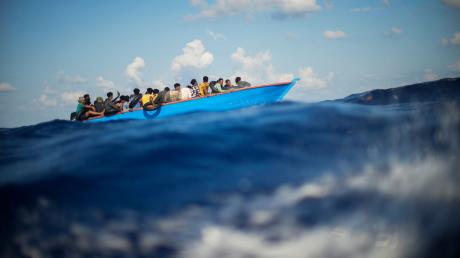 Migranten sitzen in einem Holzboot auf dem Mittelmeer, südlich der italienischen Insel Lampedusa.