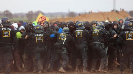 Polizisten drängen Demonstranten am Rande des Braunkohletagebaus bei Lützerath zurück. Die Polizei habe «hochprofessionell» gearbeitet, so NRW-Innenminister Reul.