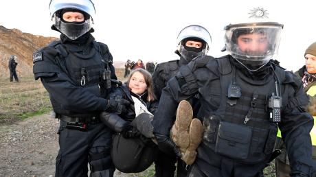 Polizisten tragen die schwedische Klimaaktivistin Greta Thunberg vom Rand des Braunkohlentagebaus Garzweiler II weg.