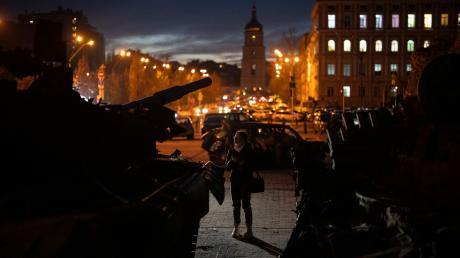 Eine Frau steht vor einer Ausstellung zerstörter russischer Panzer und gepanzerter Fahrzeuge in der Kiewer Innenstadt.
