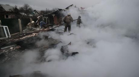 Feuerwehrleute löschen ein Feuer nach Beschuss im ukrainischen Charzysk.