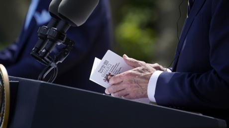 US-Präsident Joe Biden schaut während der Pressekonferenz im Rosengarten des Weißen Hauses auf seine Notizen.