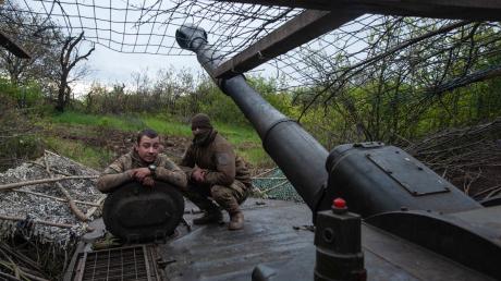 Ukrainische Soldaten schauen aus einer Panzerhaubitze.