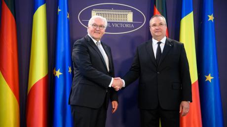 Shakehands zwischen Bundespräsident frank-Walter steinmeier (l.) und dem rumänischen Ministerpräsidenten Nicolae-Ionel Ciuca.