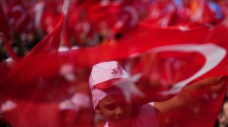 Die Anhänger des türkischen Präsidenten und Präsidentschaftskandidaten der Volksallianz Erdogan schwenken Nationalflaggen bei einer Wahlkampfveranstaltung.