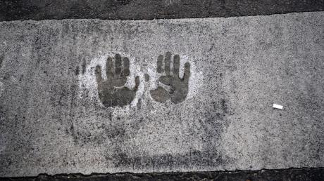 Der Abdruck von zwei Händen bei einer Straßenblockade der Letzten Generation auf dem Mühlendamm in Berlin.