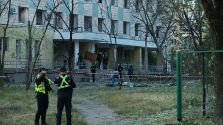 Polizisten in Kiew inspiziert ein Gebäude, das bei einem russischen Nachtangriff beschädigt wurde.