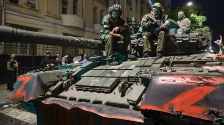 Angehörige des Militärunternehmens Wagner Group sitzen auf einem Panzer auf einer Straße in Rostow am Don, Russland, bevor sie einen Bereich im Hauptquartier des südlichen Militärbezirks verlassen.