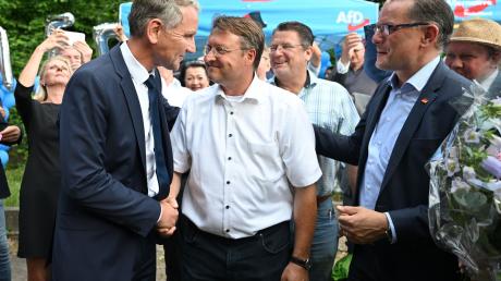 Björn Höcke, Vorsitzender der AfD Thüringen (l) und Tino Chrupalla, AfD-Bundesvorsitzender (r) gratulieren dem Wahlsieger Robert Sesselmann (AfD,M).