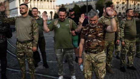 Eine Gruppe ukrainischer Soldaten betet während eines von einer örtlichen christlichen Kirche organisierten Gottesdienstes.