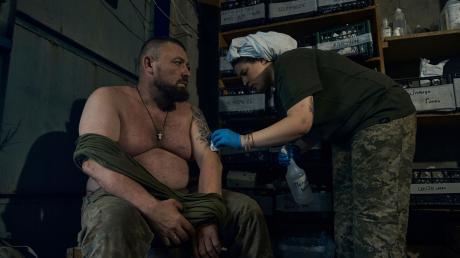 Eine Sanitäterin verarztet einen ukrainischen Soldaten in Bachmut.