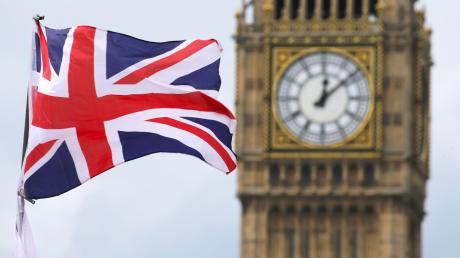 Eine Britische Fahne weht vor dem berühmten Uhrturm Big Ben in London.
