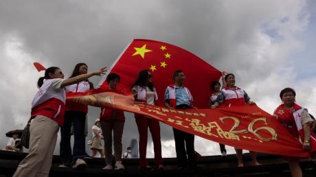 Peking-Befürworter halten chinesische Fahnen anlässlich des 26. Jahrestages der Übergabe der Kontrolle über Hongkong von Großbritannien an China. Führende EU-Vertreter erheben mit einem neuen Bericht zu den Entwicklungen in Hongkong schwere Vorwürfe gegen die politische Führung in Peking.