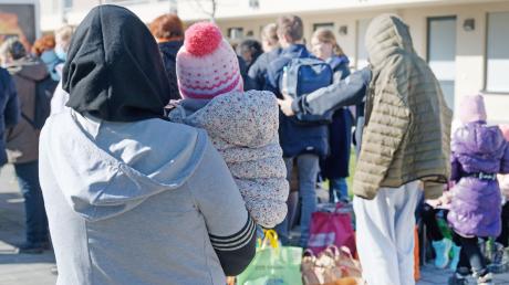 Geflüchtete stehen vor den Gebäuden einer Flüchtlingsunterkunft in Köln.