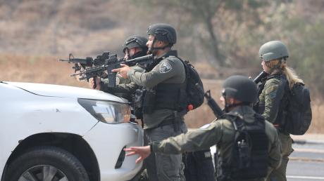 Israelische Streitkräfte gehen hinter einem Fahrzeug in Sderot in Stellung.