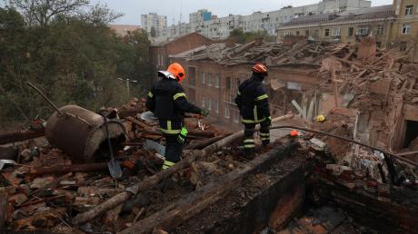 Feuerwehrleute suchen nach einem Luftangriff in Charkiw nach Opfern.