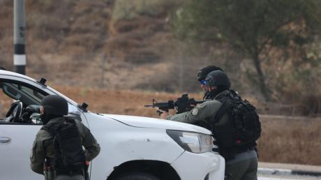 Israelische Streitkräfte gehen hinter einem Fahrzeug in der Grenzstadt Sderot in Stellung.