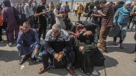 Palästinenser, einige mit ausländischen Pässen, warten am Grenzübergang Rafah auf Hilfe und eine mögliche Einreise nach Ägypten.